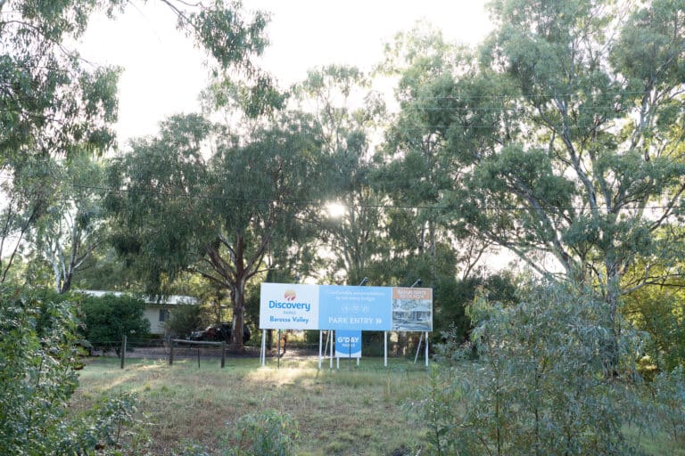 A blue sign welcoming guests to the Discovery Parks - Barossa Valley set within Australian bush