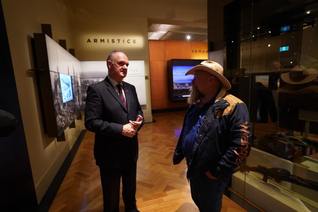 The host of WUDU TV interviews a staff member in the Armistice gallery of the Australian War Memorial.