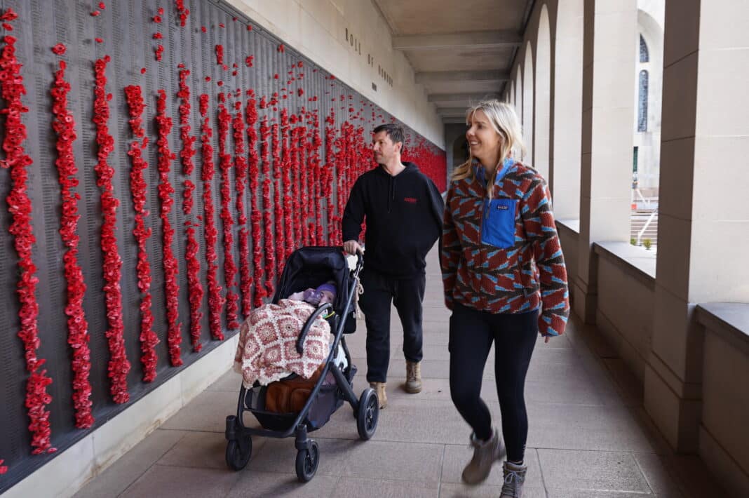 Visitors pay their respects by walking along the poppy-filled Roll of Honour at the Australian War Memorial.