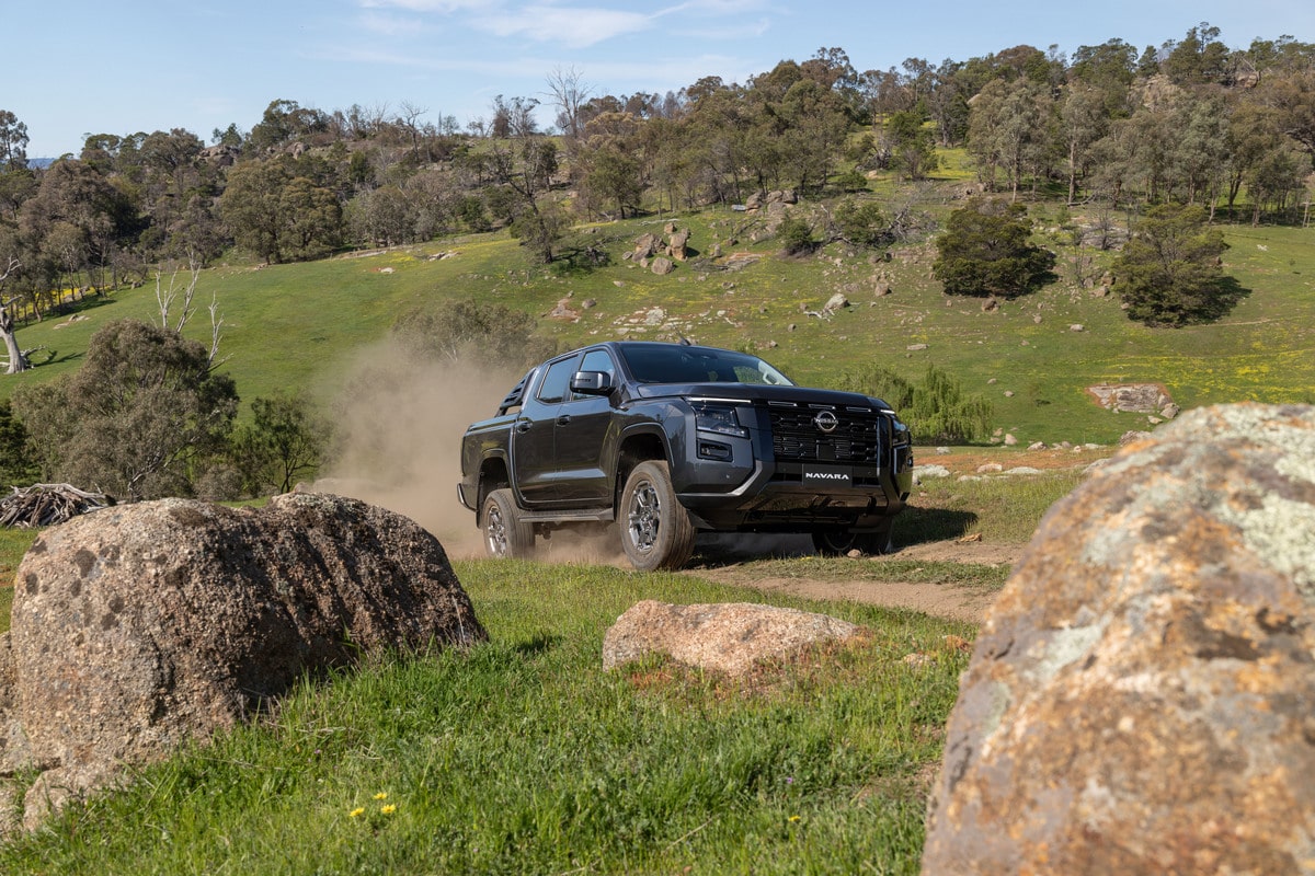 The MY26 Nissan Navara ST-X climbing up a dirt track features a bi-turbo engine for great torque in driveway and highway speeds