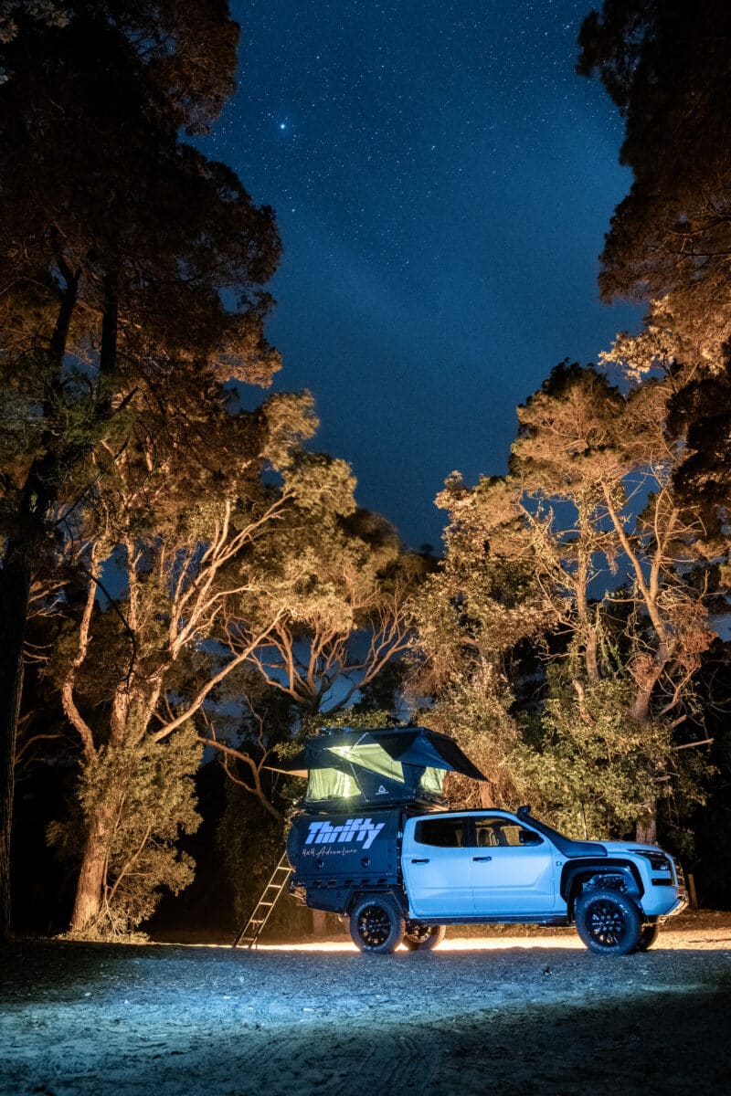 Converted Mitsubishi Triton with a rooftop tent beneath a starlit sky in the Northern Territory.  
