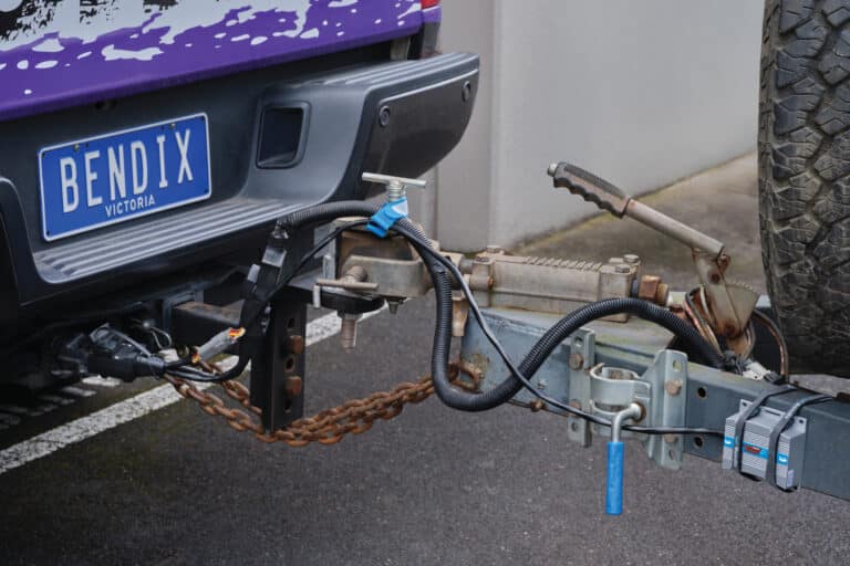 Close up of a hand turning a large dial to control the Bendix Ultimate Tow Portable+ via bluetooth connection