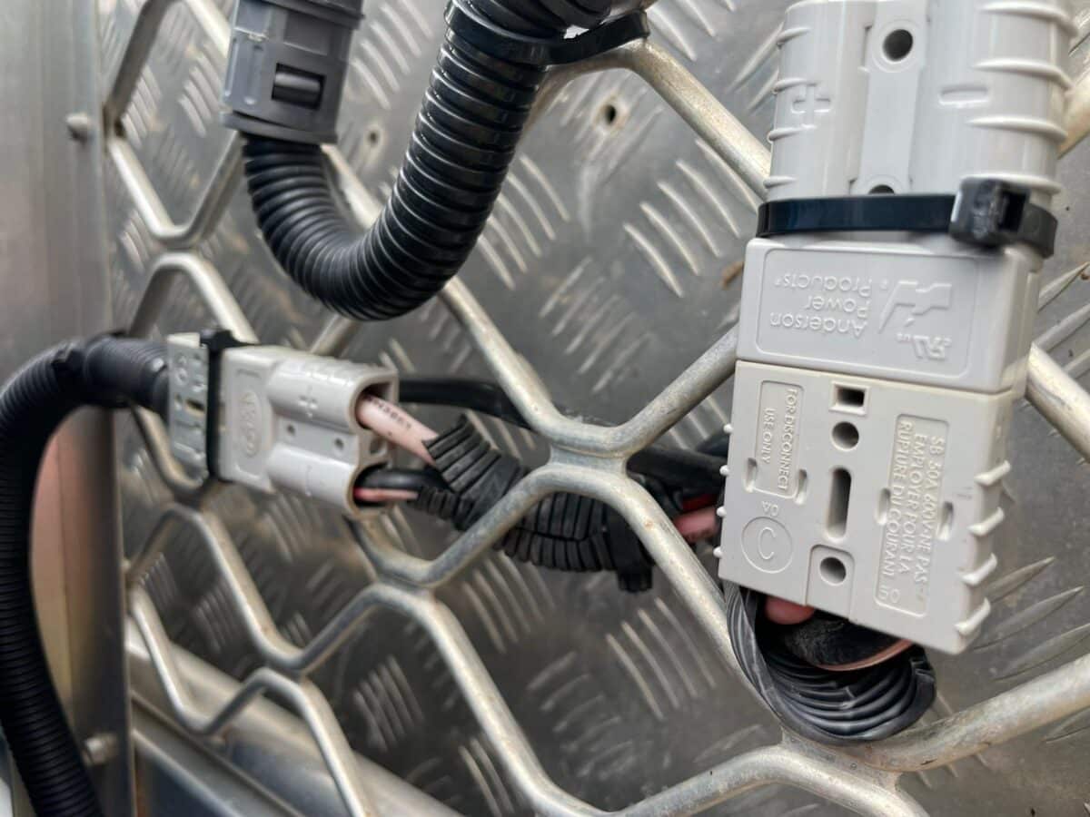 A 12V Anderson Plug connection attached to a grill. The Adventuring Pals fitted an Anderson Plug to their 12V fridge system to prevent disconnection mid-transit
