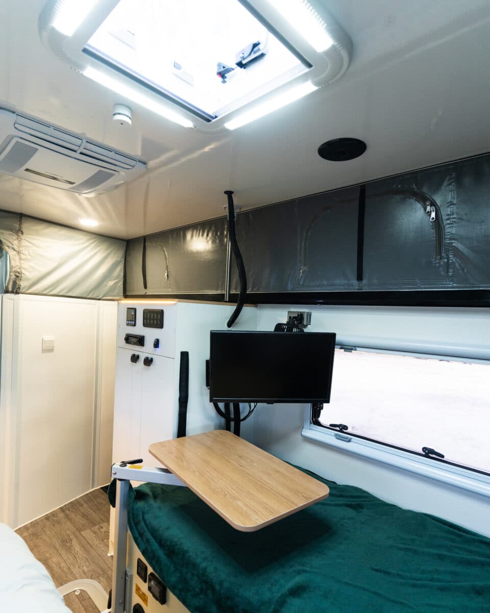 One of two small tables pivoting on a leg allow for dining in the arctic glacier 14TS hybrid camper footprint