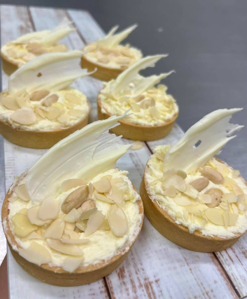 close-up of the delicious custard tarts with no soggy bottoms, topped with cream, almonds, and white chocolate, from Heinemann's Country Bakery in Charleville