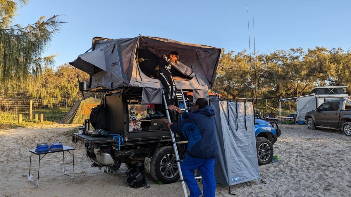 A young boy exits a roof top tent. Static roof top weight limits are greater than dynamic weights allowing for a family to use a roof top tent.