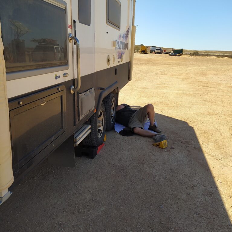 Peter under the van getting the jack in place