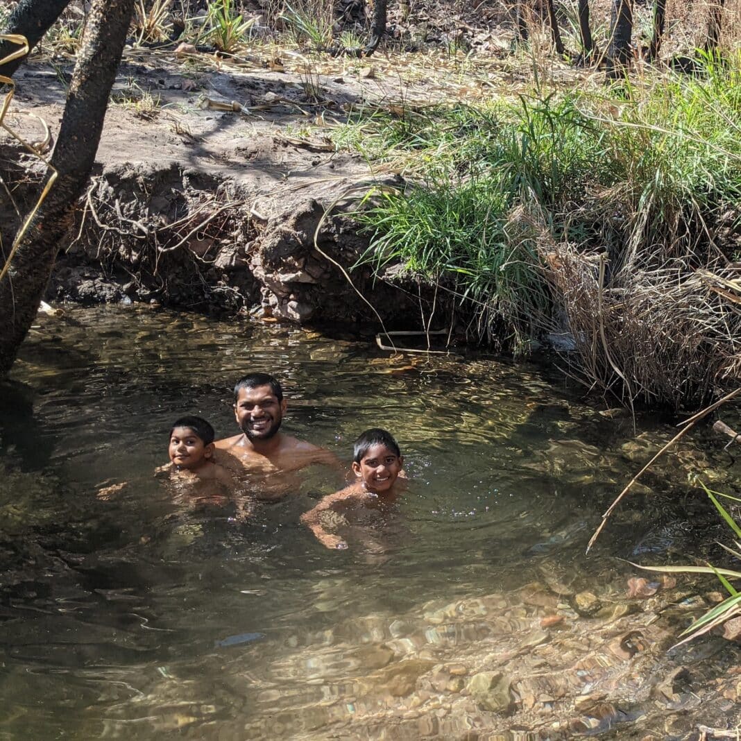 Two boys and their father cool down at the Wuggubun Aboriginal Community Campground accessible via the Gibb River Road