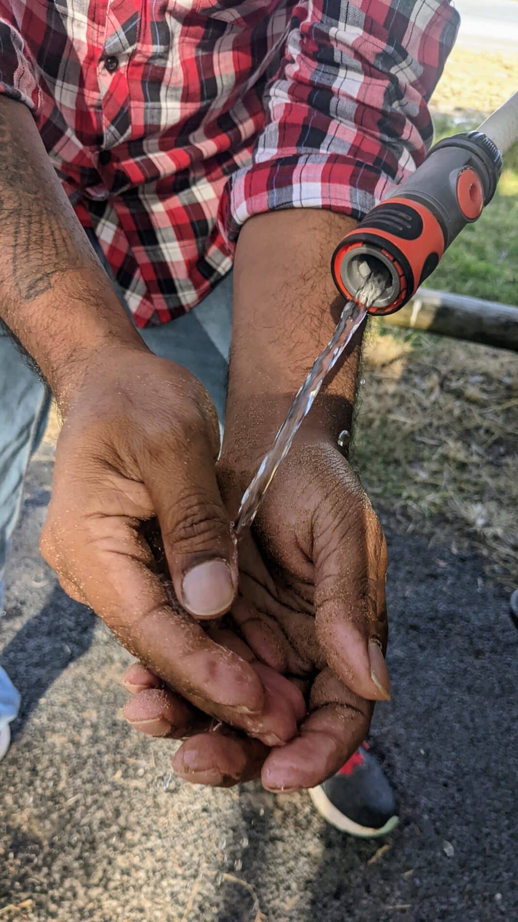 add-a-tap-hose-jerry-can-water-hackPXL_20220619_232626456 Washing sandy hands with a DIY jerry can hose control valve setup.