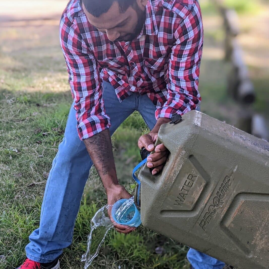 add-a-tap-hose-jerry-can-water-hackPXL_20220619_232822162.PORTRAIT Pouring drinking water easily using a modified jerry can spout and hose.
