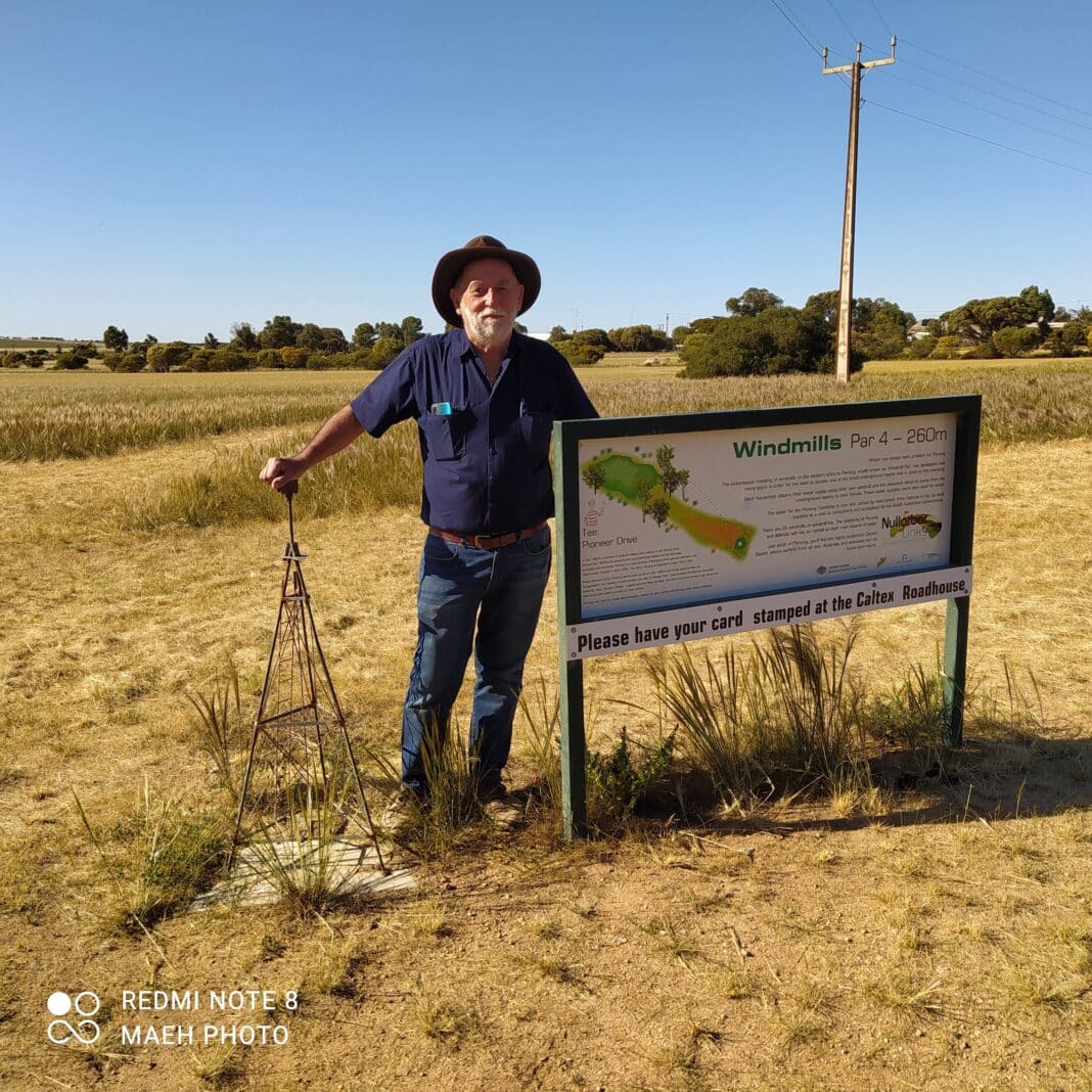 Peter Huth stands at mini windmill and signage at the windmills hole in SA on the Nullarbor Links golf course