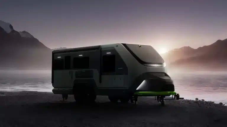 Exterior view of a power-generating RV trailer set up off-grid at dusk