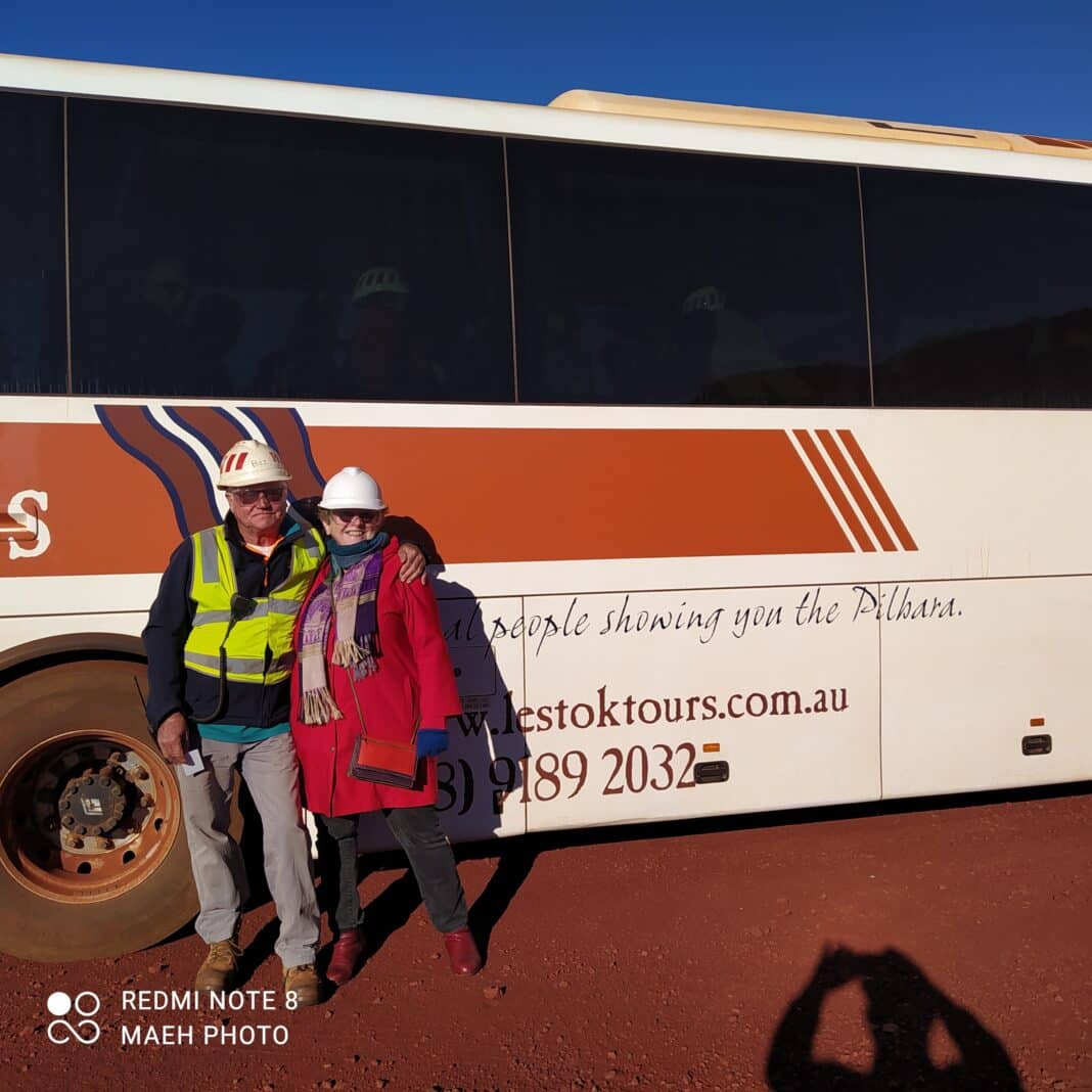 rio-tinto-tom-price-mine-tour09 Baz, our tour guide and Alison Tour guide Baz and a guest wearing hard hats posing in front of the Lestok Tours bus.