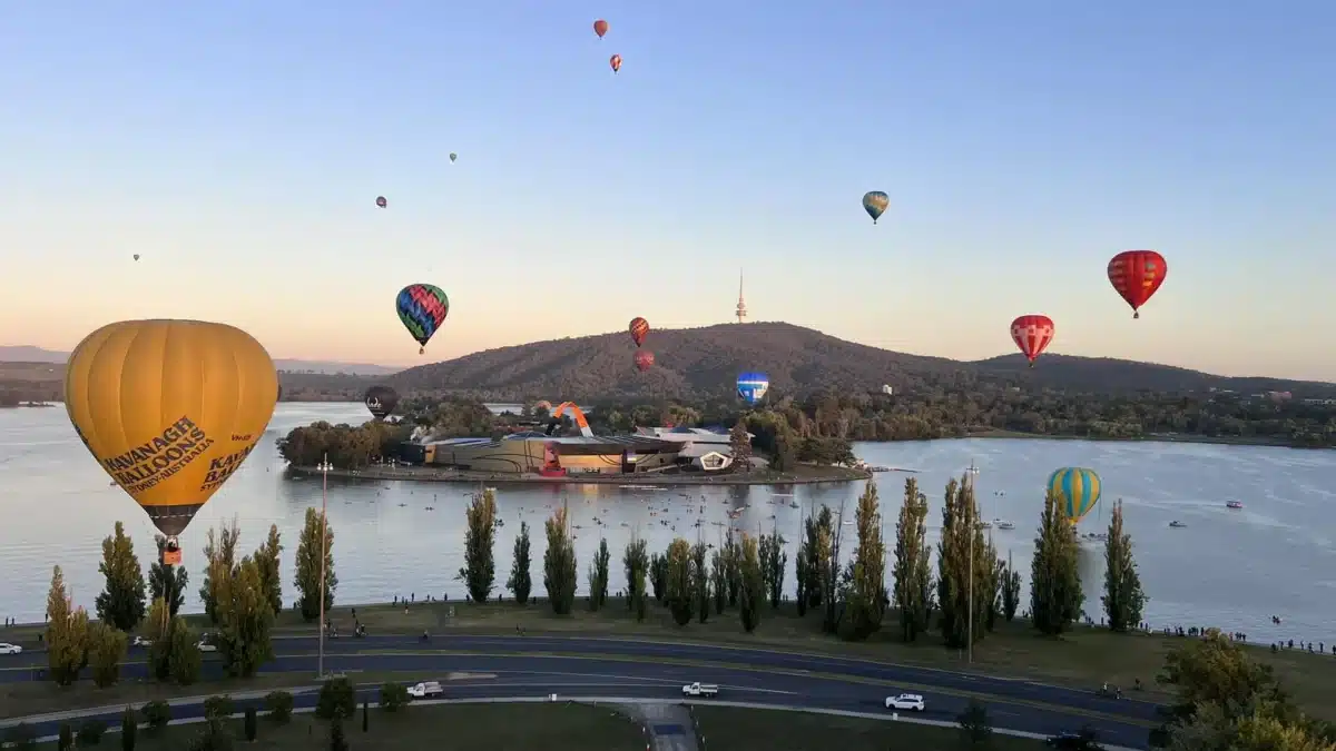 Hot air balloons floating over Lake Burley Griffin in Canberra at sunrise