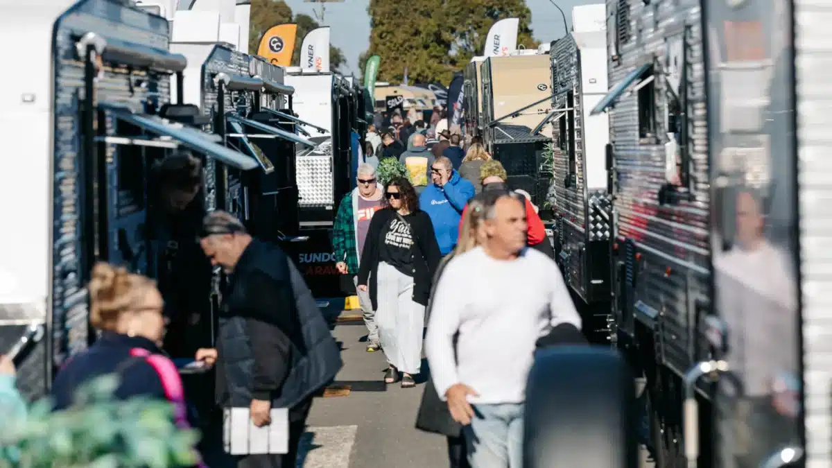 Visitors walking between caravans at a caravan and camping expo