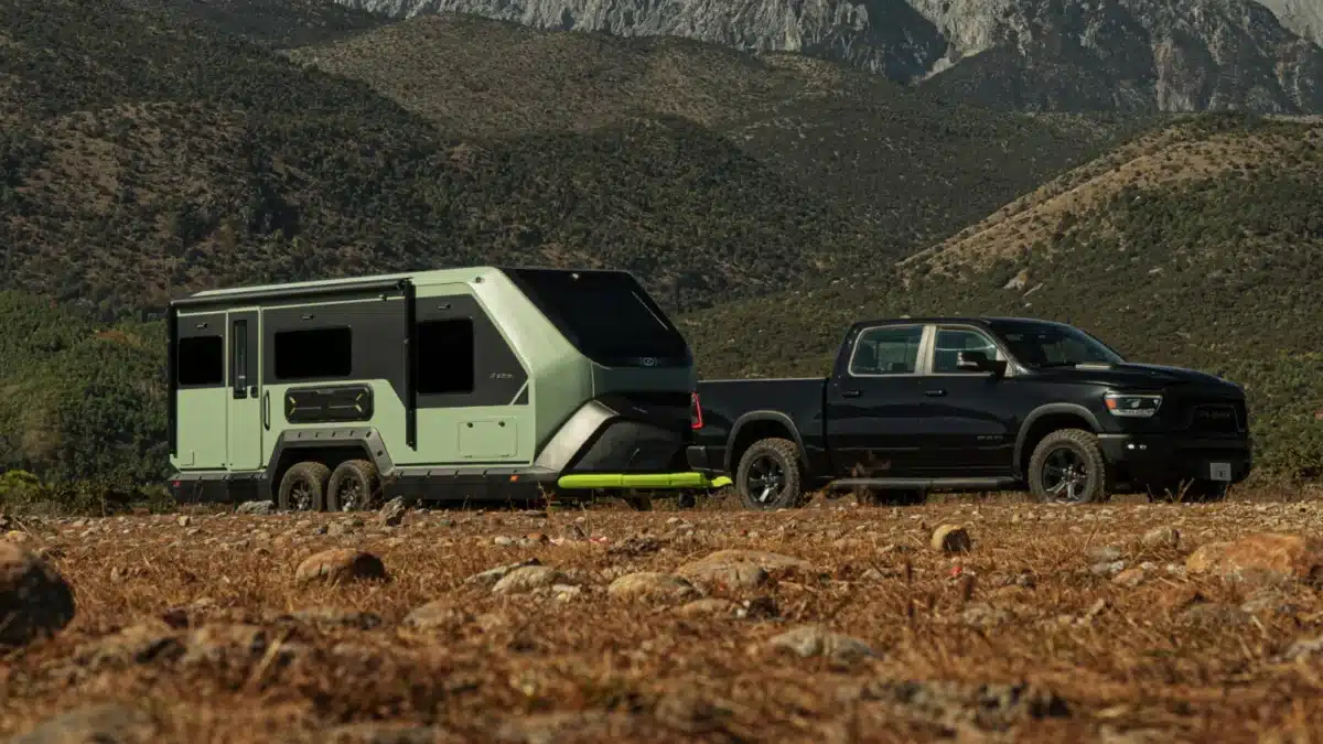 Evotrex PG5 RV trailer parked off-grid with tow vehicle in rugged landscape