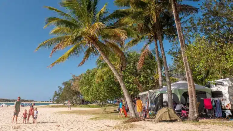 Young family camping beside their caravan on an Australian beach during a holiday trip