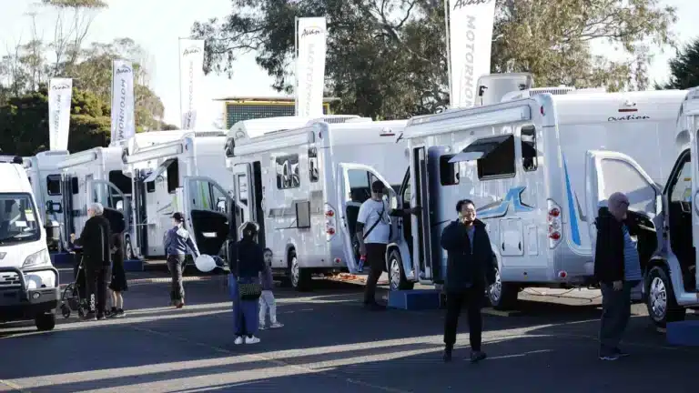 Visitors walking through a caravan and motorhome display at an Outdoor Living & Caravan Expo
