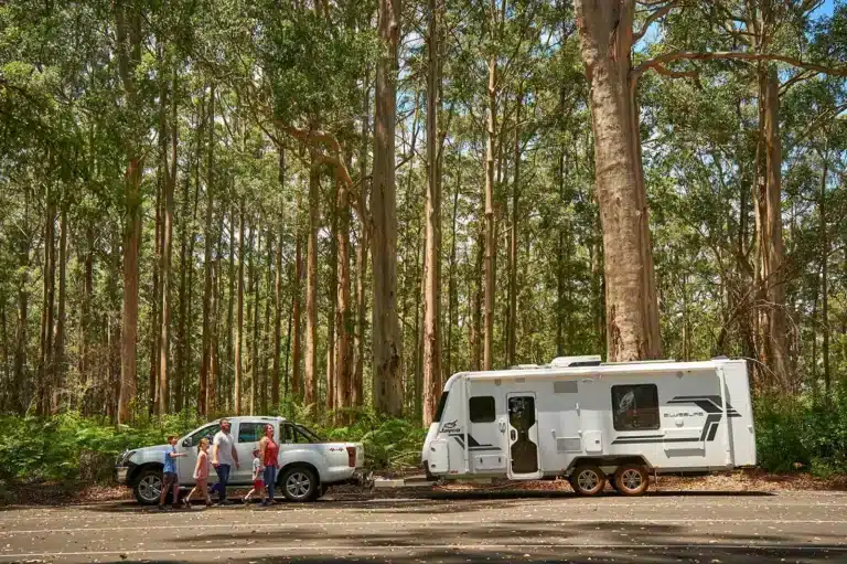 Regional road trip with caravan parked in bushland, reflecting Australian summer travel trends