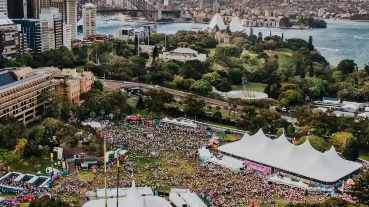 Aerial view of a large summer festival crowd in central Sydney with the Harbour Bridge and Opera House in the background
