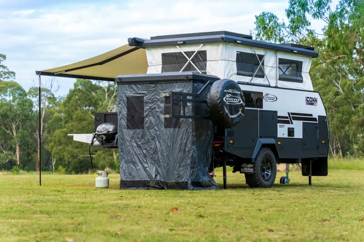 black and white campervan being fully set up featuring outdoor shower on rear