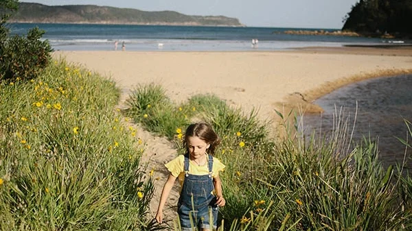 kid running through tall green grass