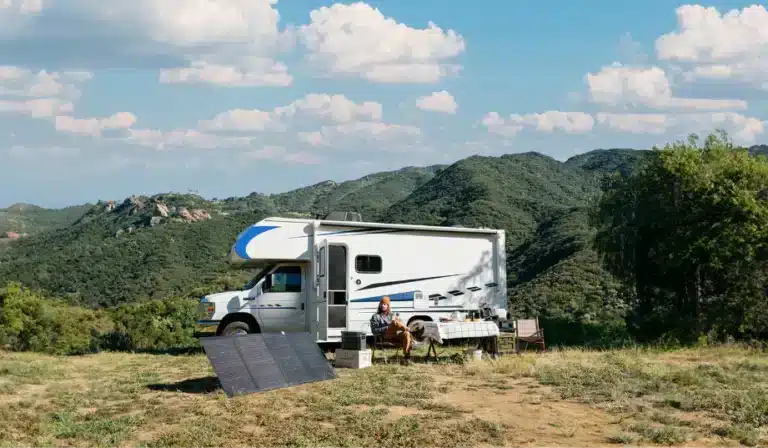 view of caravan rv sitting on top of hill set up with electronics