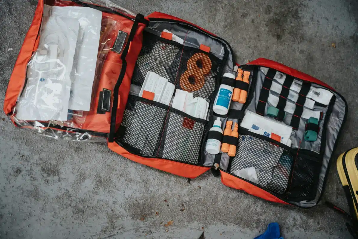 Open first aid kit with contents laid out for checking before trip