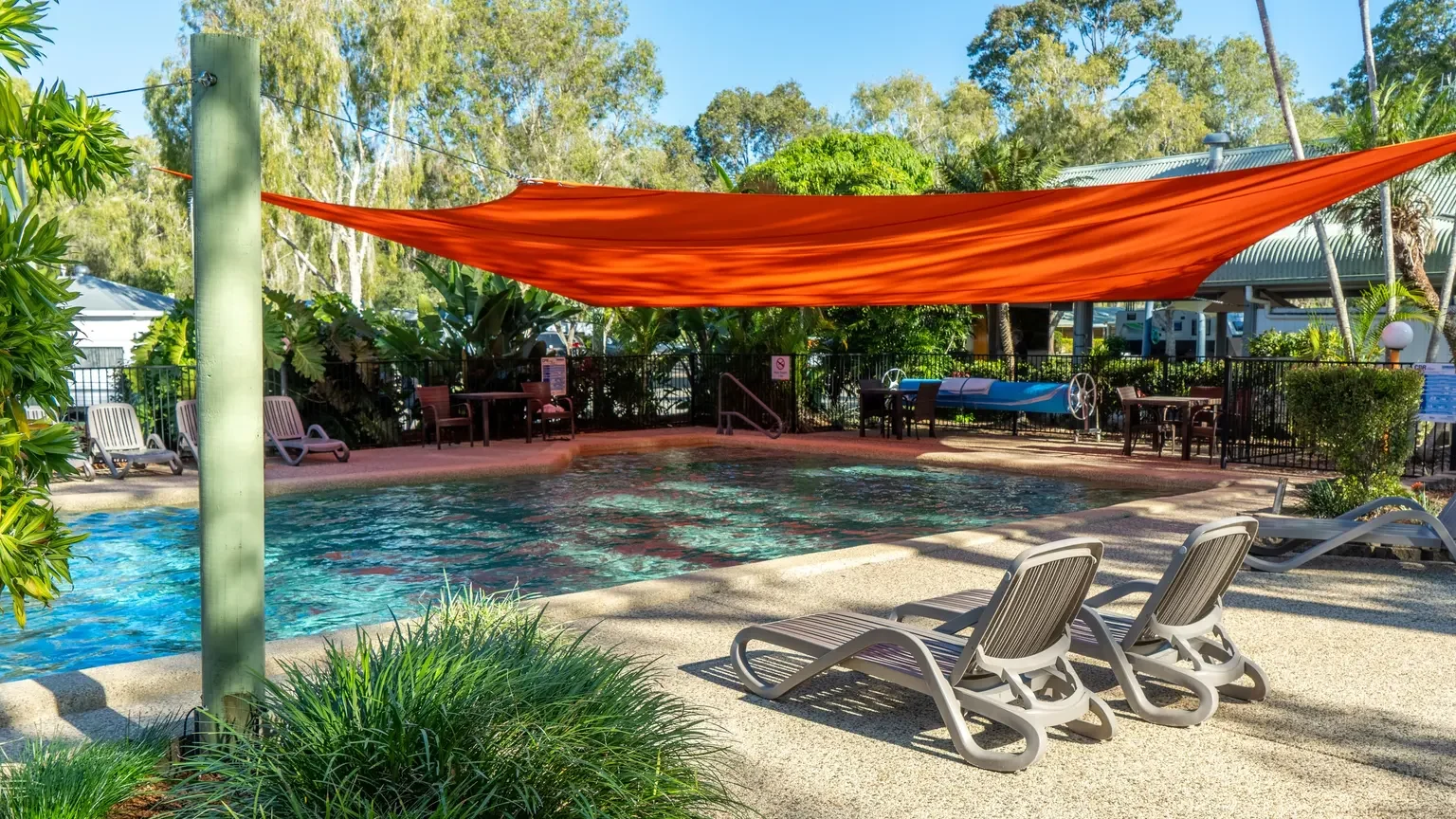 pool under red shade sail