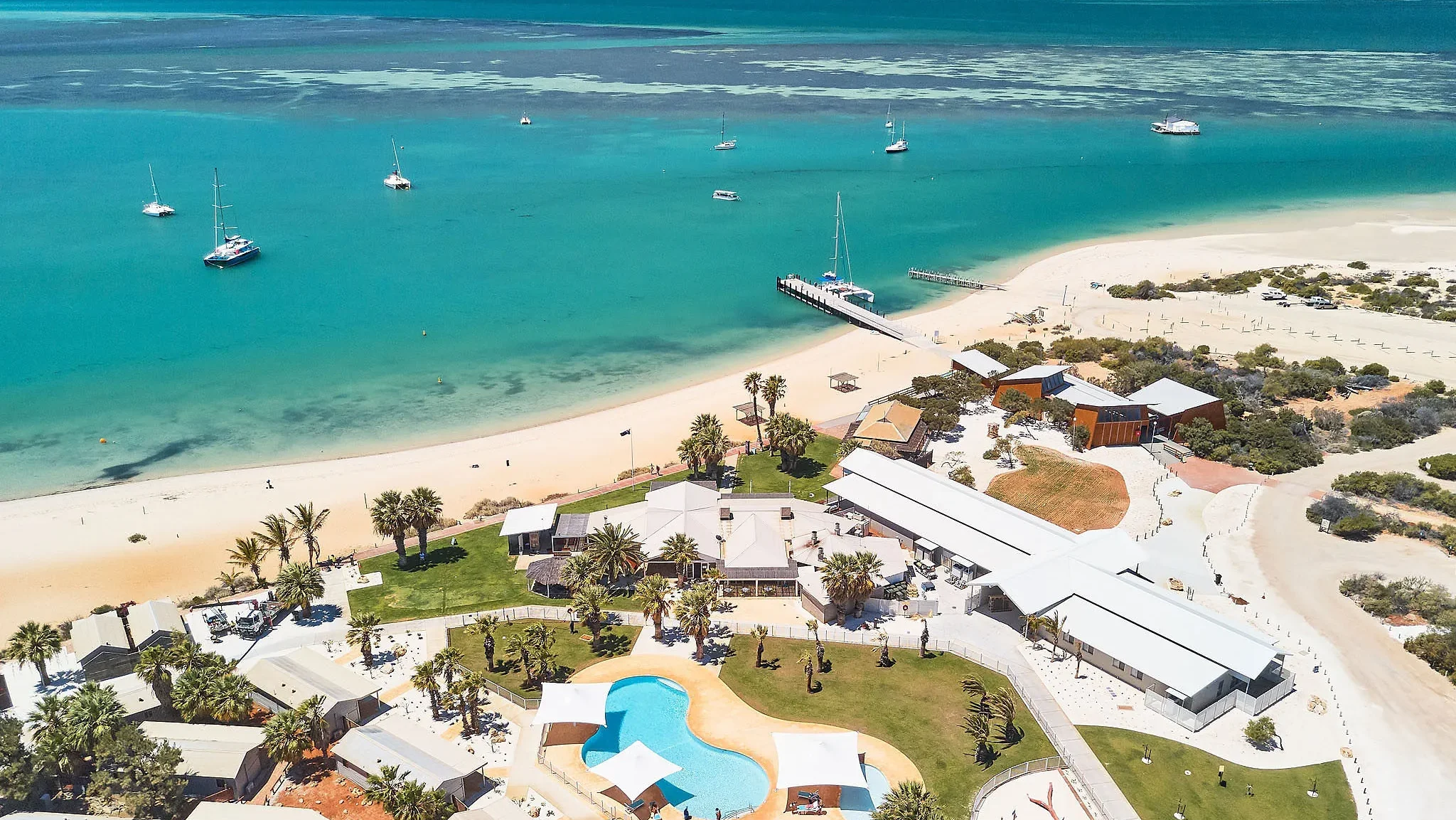 drone shot over blue water and white sandy beach