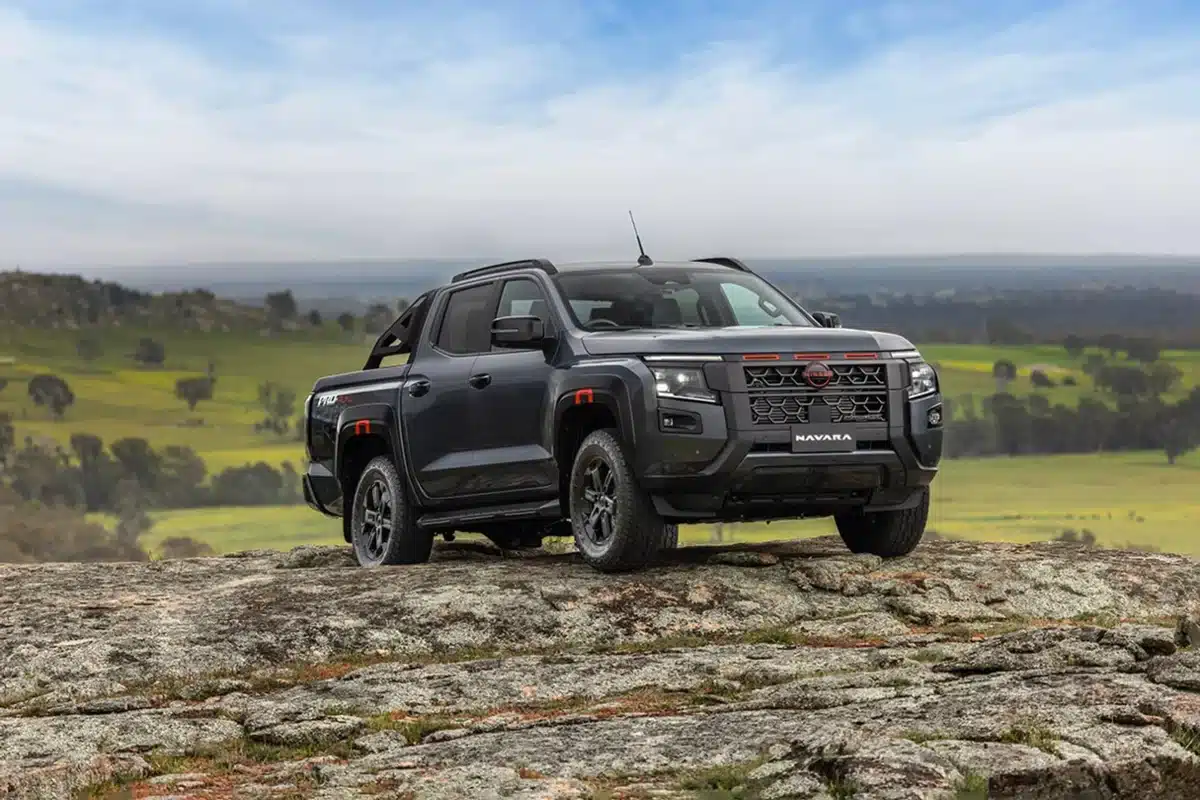 2026 nissan navara on rock offroad 4wd with green hills and scenic background