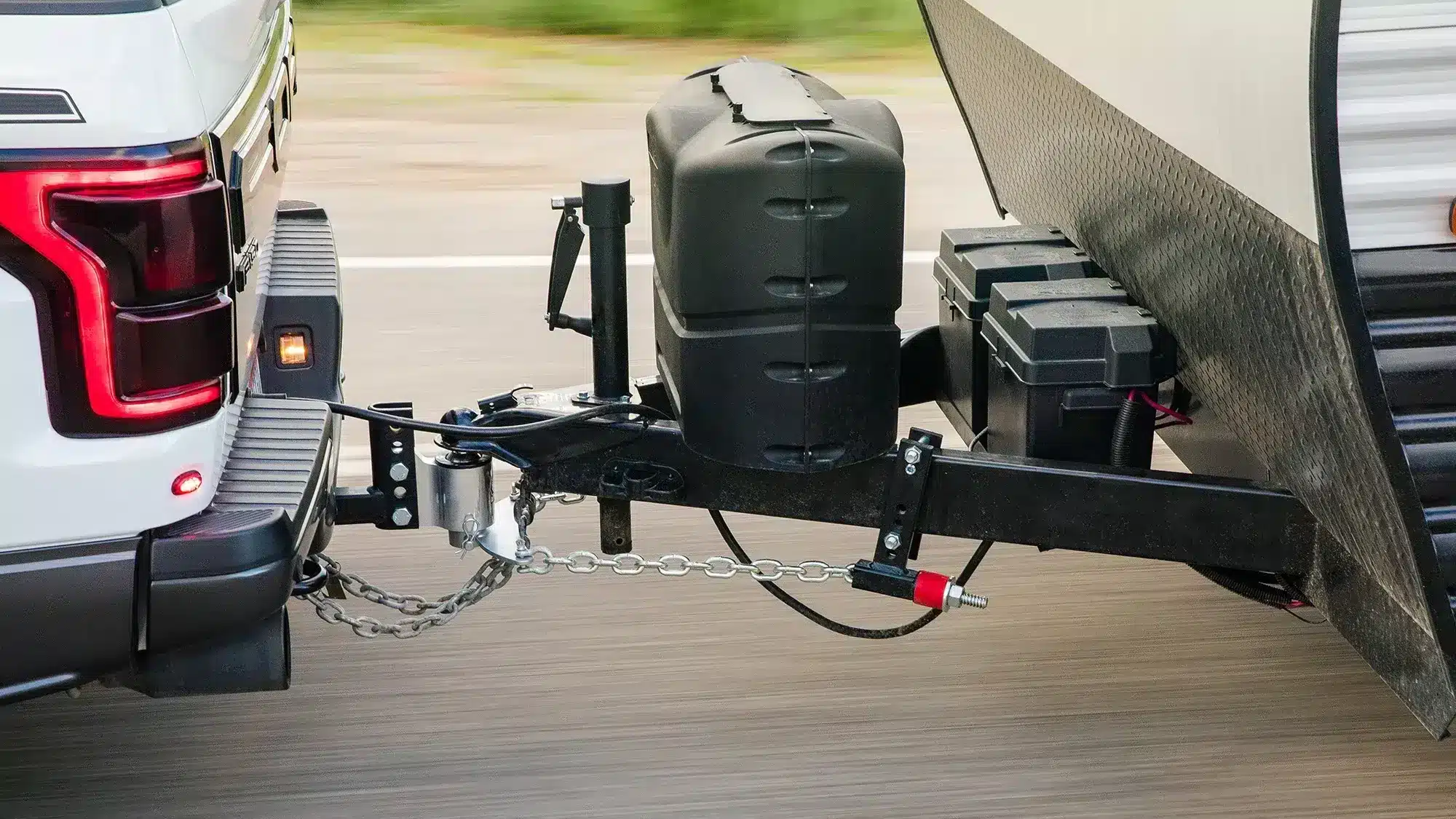 Caravan towing setup showing tow ball connection, safety chains and weight distribution hitch