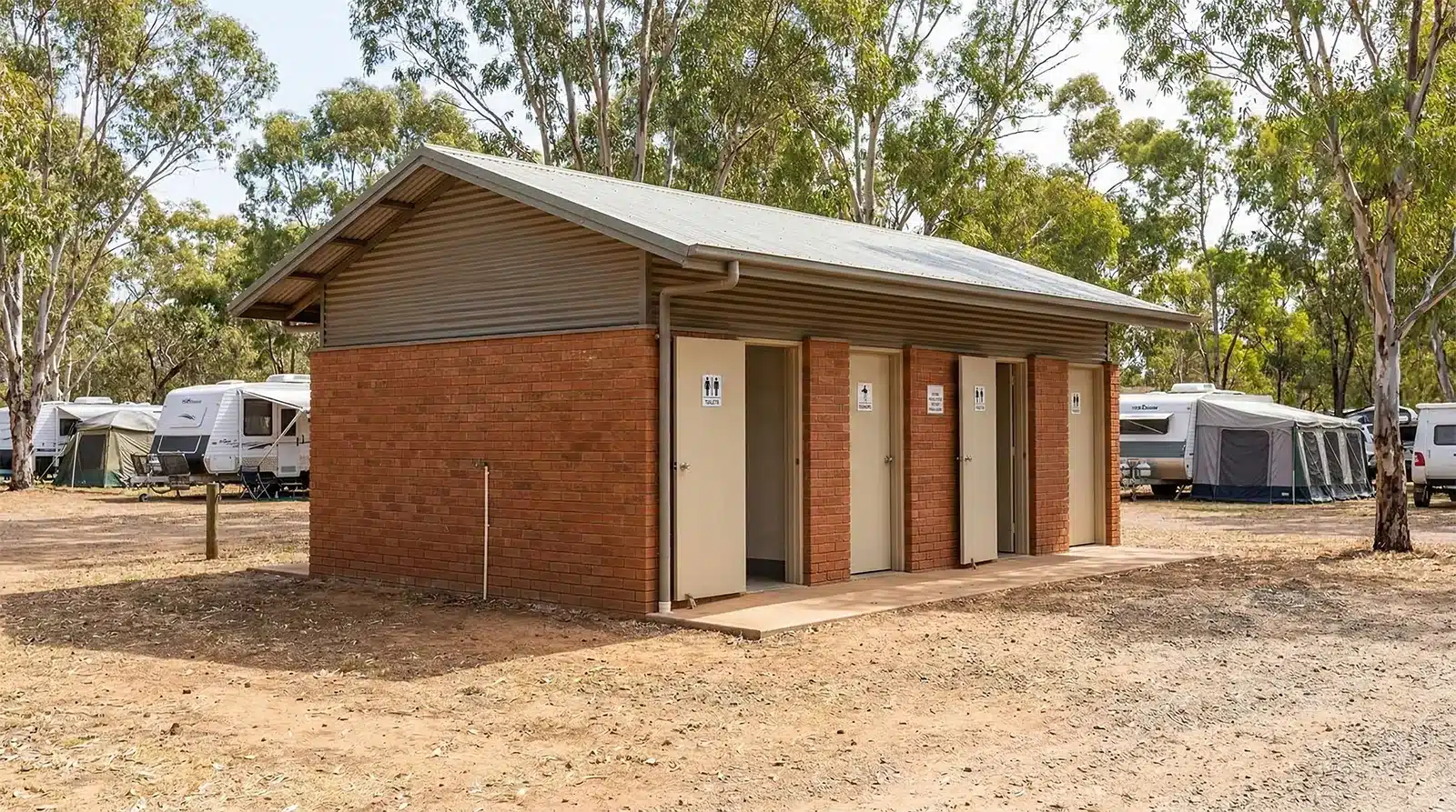 Caravan park amenities block with toilets and showers surrounded by caravans and bushland
