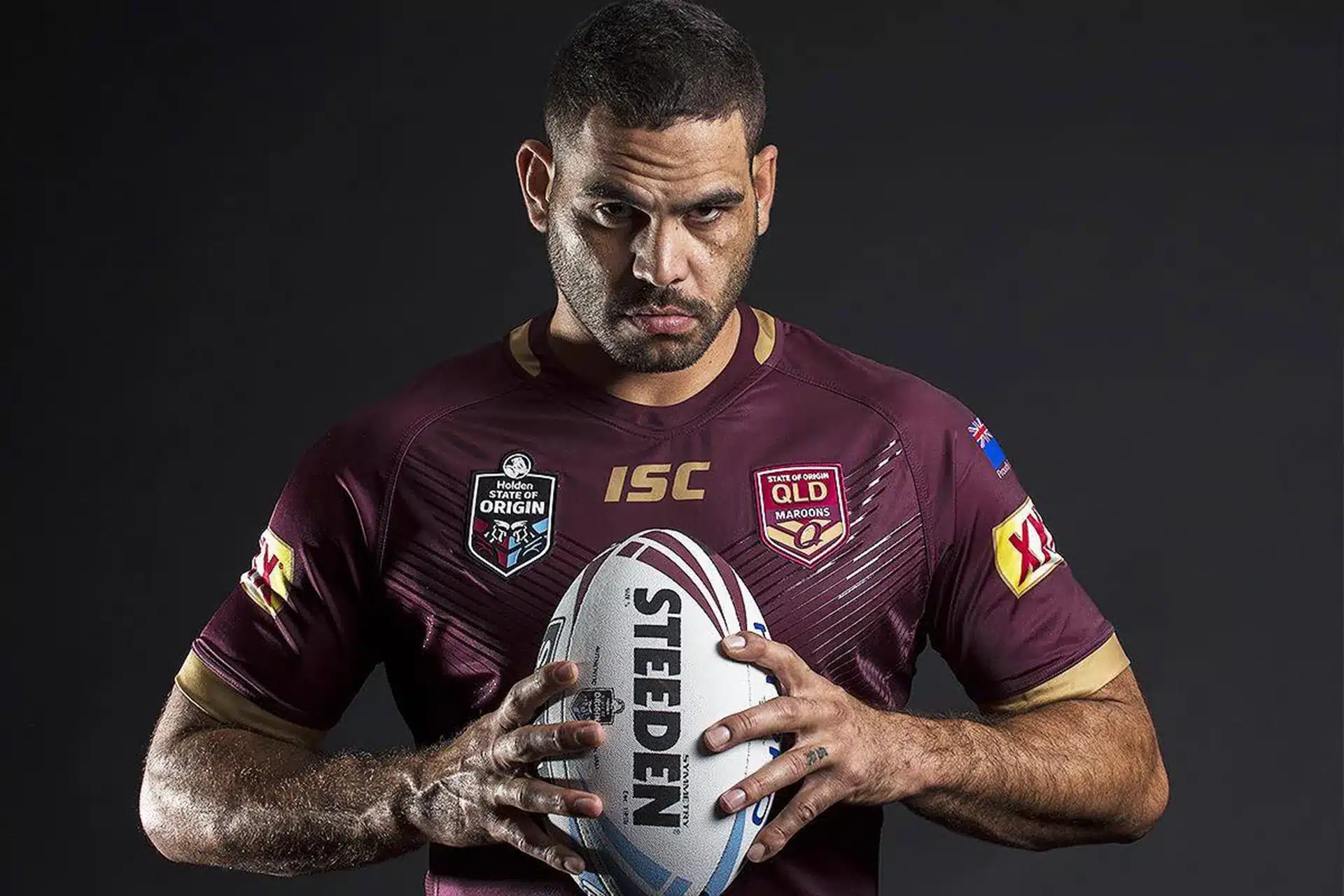 Greg Inglis in Queensland Maroons State of Origin jersey holding a rugby league ball during a promotional photo.
