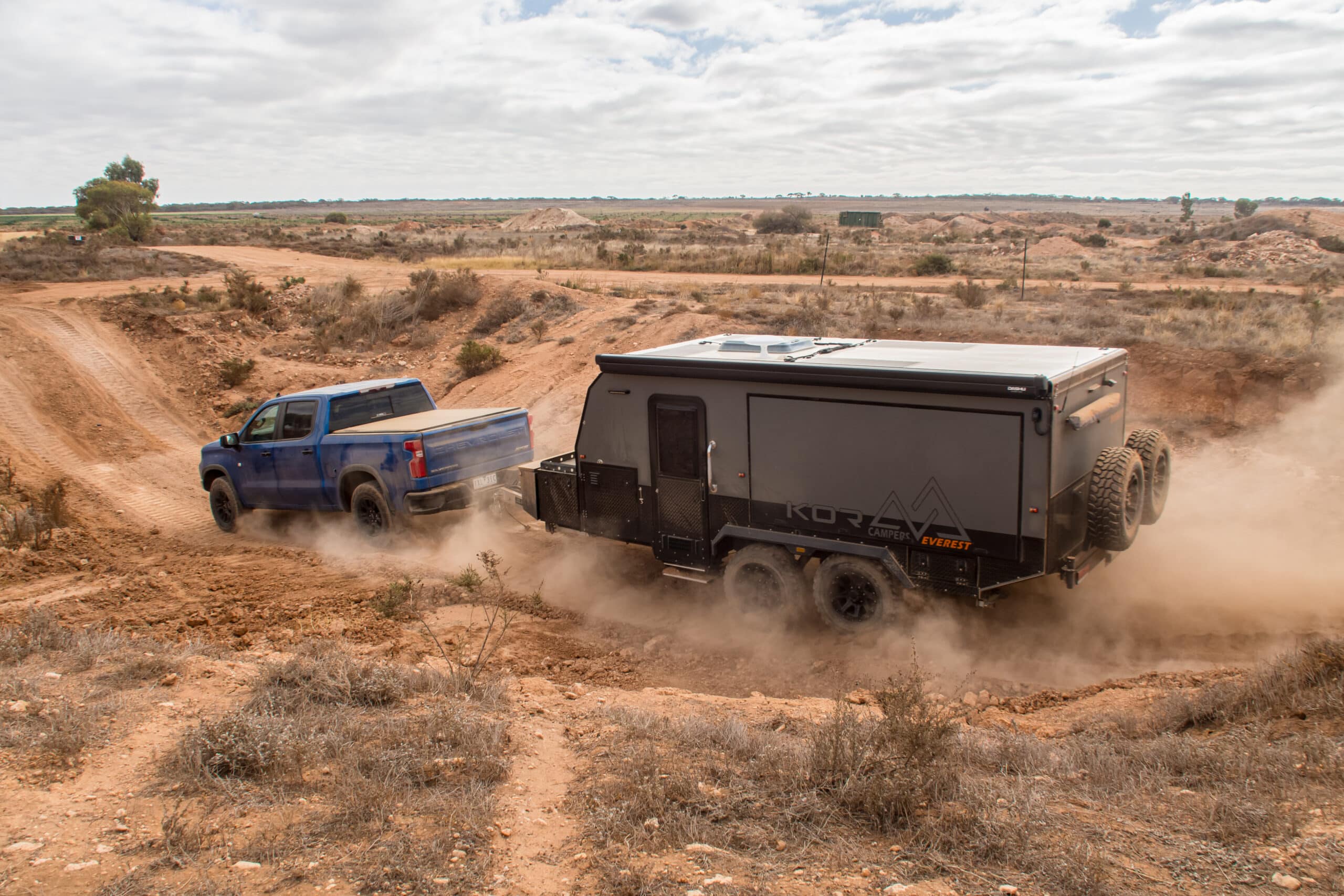 Caravan being towed on dusty dirt outback road