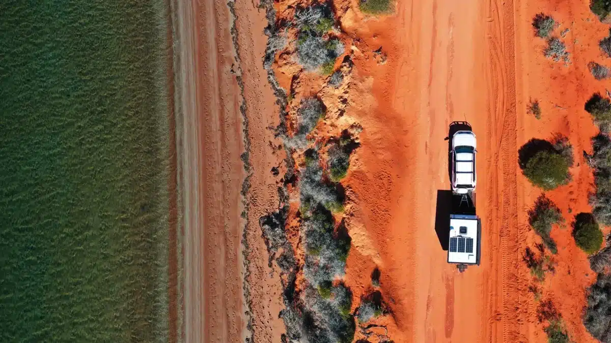 birds eye view over coastal red dirt road with caravan towing caravan