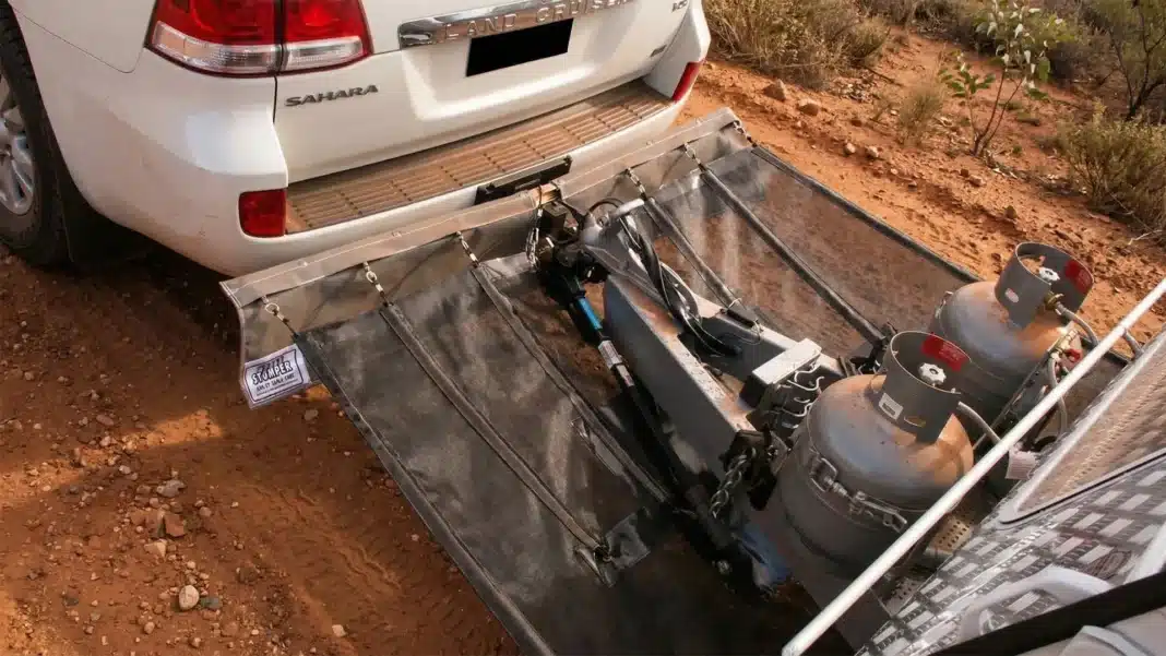 Caravan stone guard attached to hitch and chassis of car and caravan, sitting on Australian dirt road