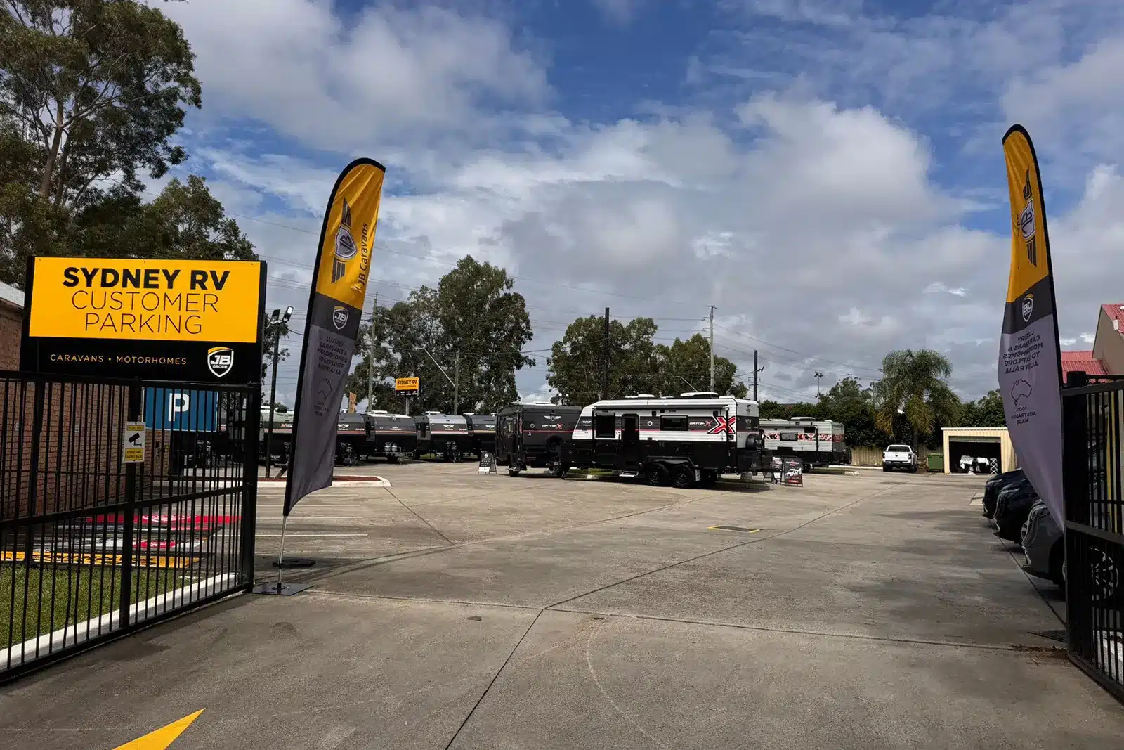 Sydney RV Penrith dealership entrance with customer parking signage and caravan yard in background.