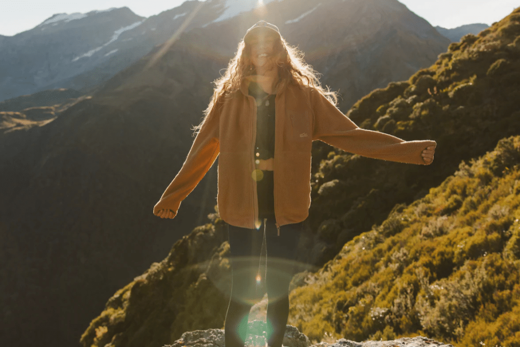 woman on mountain with sun shining in zorali fleece