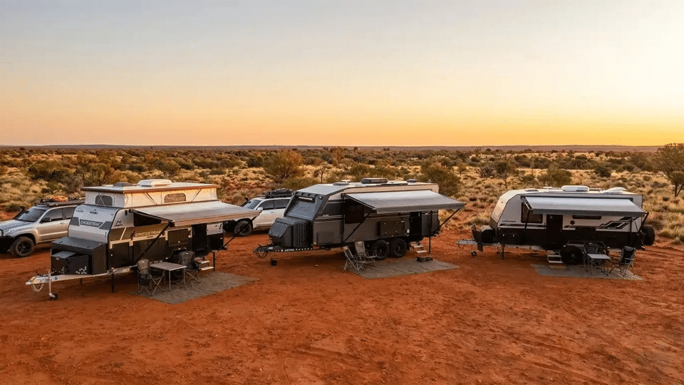 lotus and jayco caravan line up in red dirt outback australia 