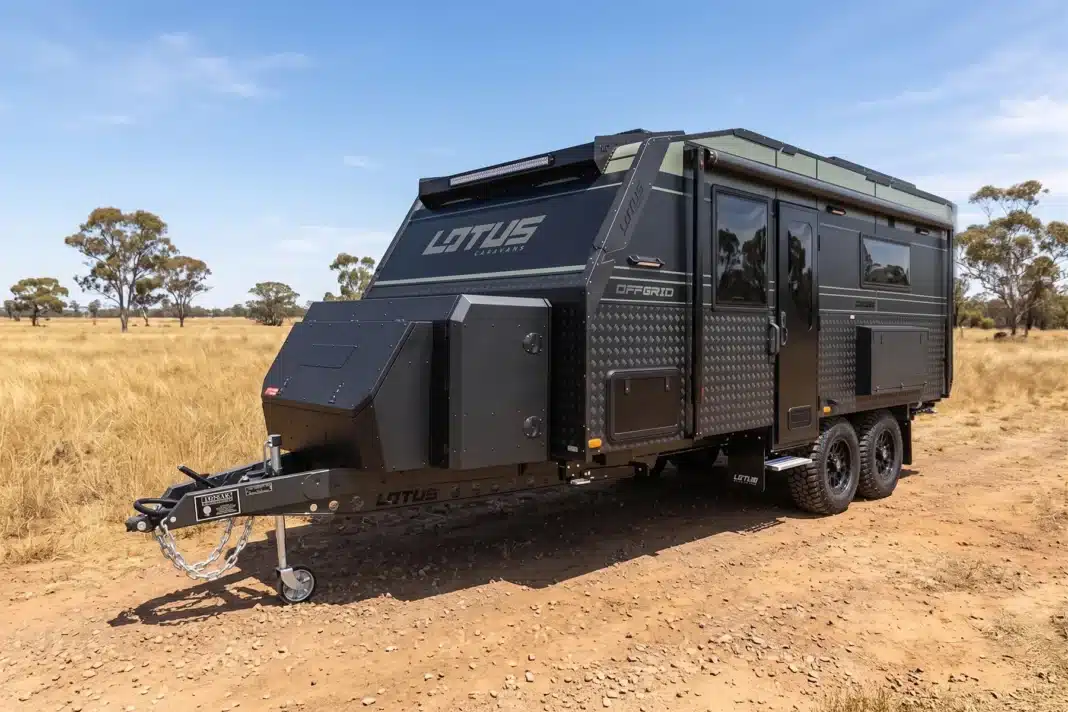 black and green caravan parked on australian plains with blue sky