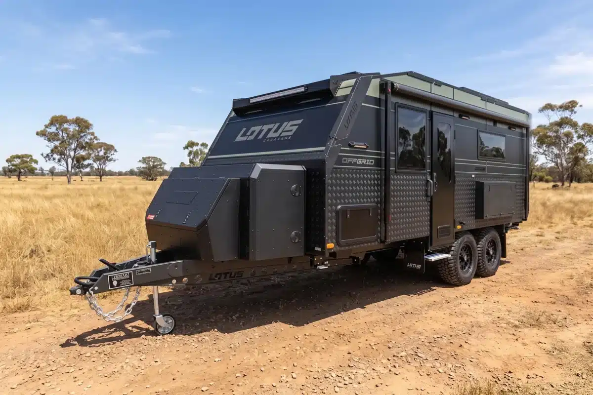 black and green caravan parked on australian plains with blue sky