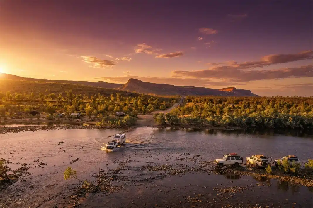 kimberly-region-4wd-sunset-water-crossing Caravan and 4WD crossing river through the Kimberley region of Western Australia with native trees in the background.