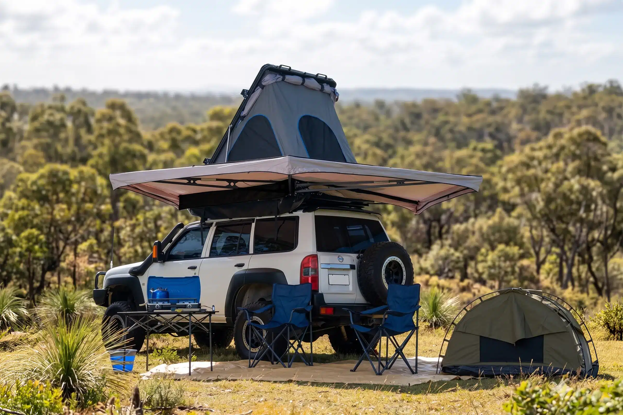 Kings 270 awning deployed at a bush campsite alongside a rooftop tent, camp chairs and swag
