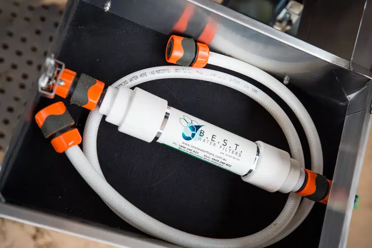 B.E.S.T. inline water filter inside a caravan storage box with hose and click-on fittings ready for use