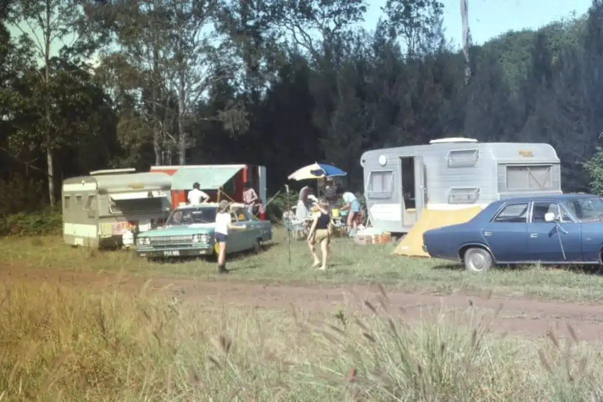 caravans and cars parked up with kids playing awnings and umbrellas