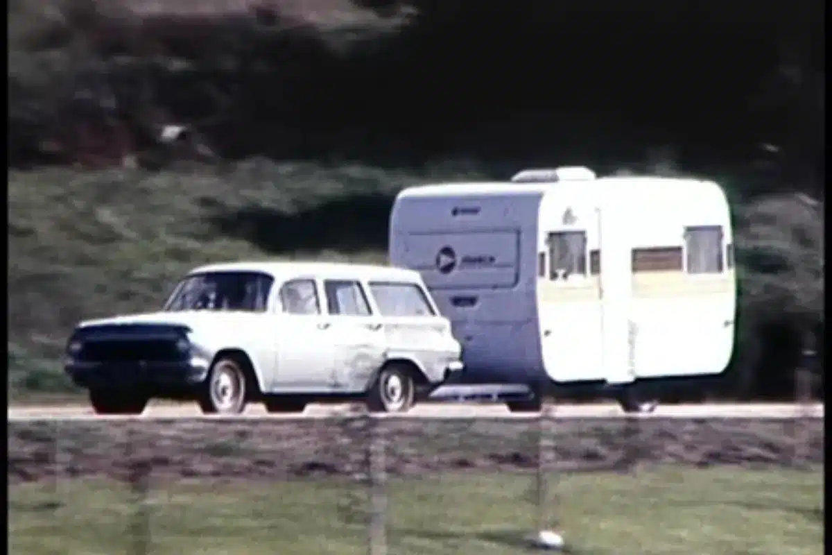 car driving on road with caravan towing behind