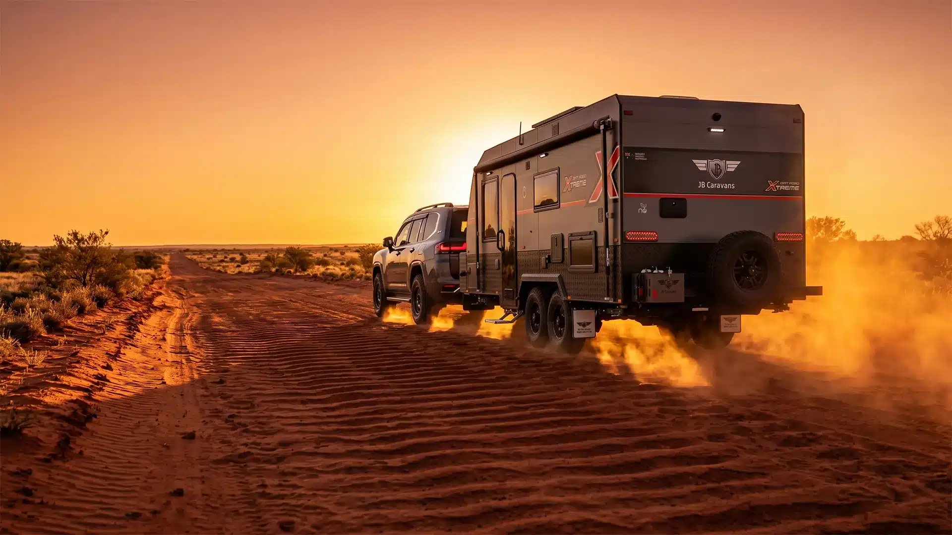 Toyota Landcruiser spraying up dust and dirt on a dirt track in australia, while towing a JB Caravans model at sunset