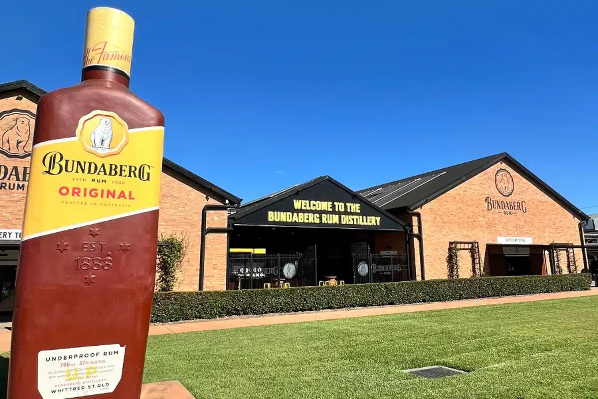 Giant Bundaberg Rum Original bottle statue outside the Bundaberg Rum Distillery entrance, a popular day trip destination from Woodgate Beach