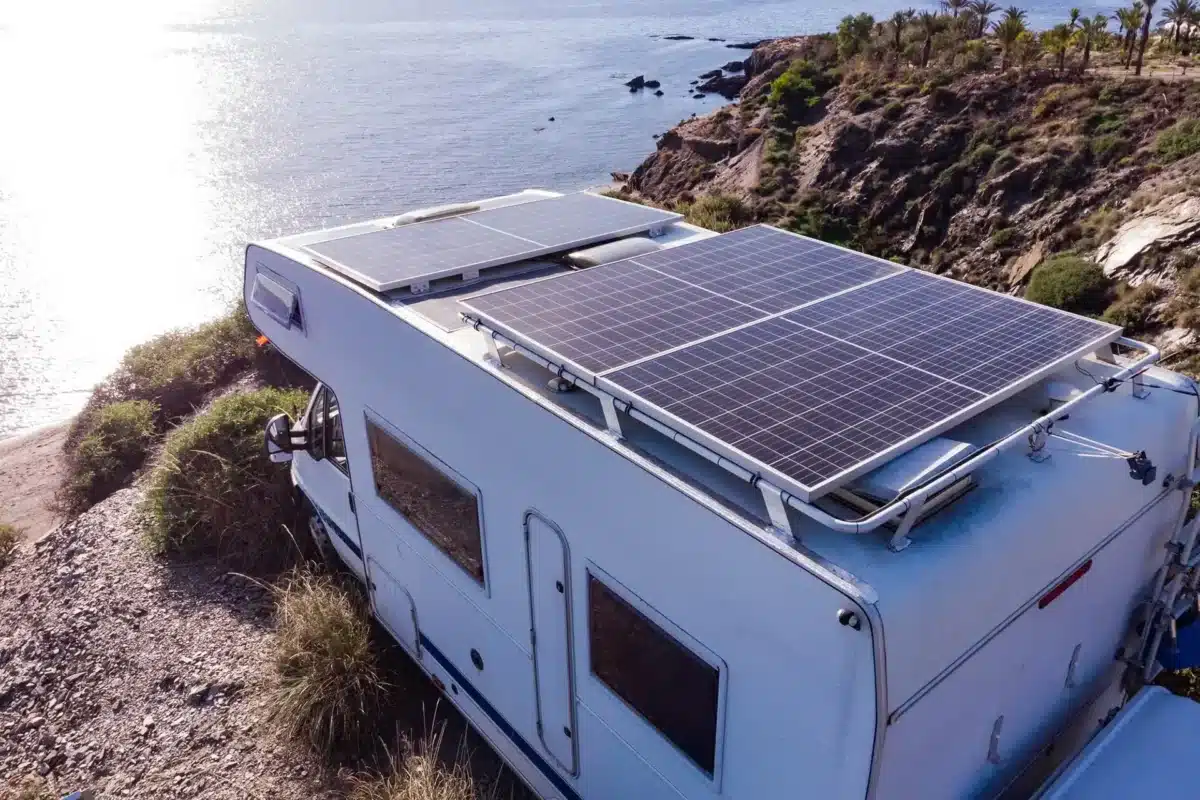 caravan motorhome looking at beach from cliff with solar panels